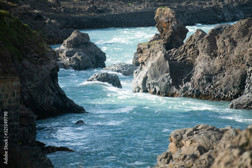 Blue water in raging river stream among sharp rocks