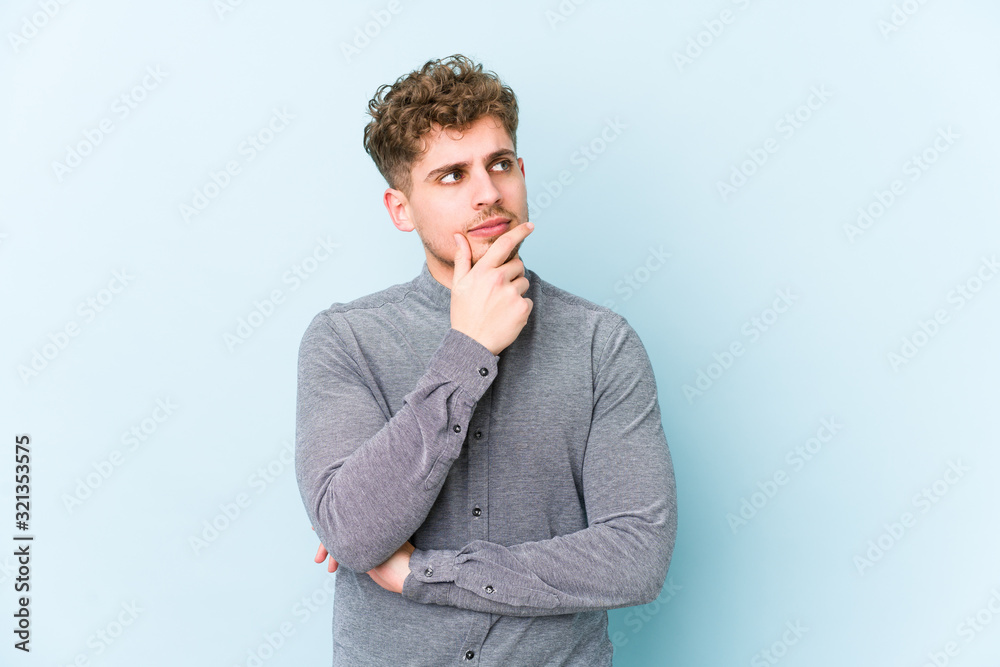 Φωτογραφία Young blond curly hair caucasian man isolated contemplating, planning a strategy, thinking about the way of a business