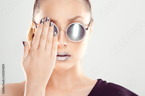 Portrait young woman in glasses covering one eye with a mine, isolated on white background