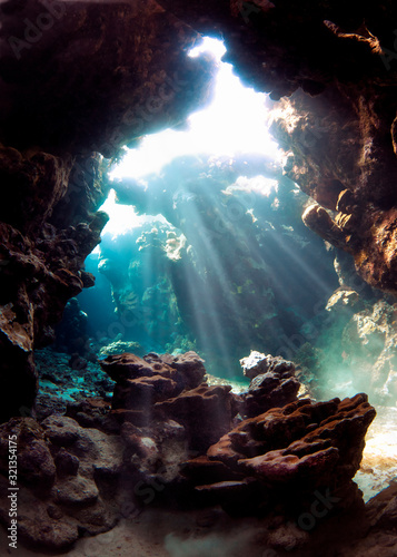 Underwater world. A cave under water permeated with rays of sunlight. © Sergey