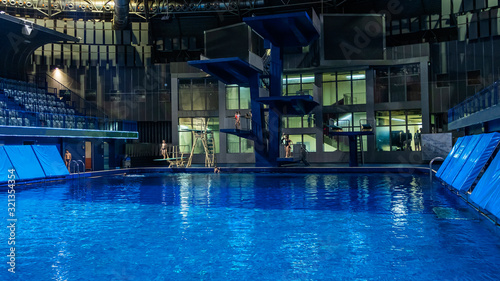 Public swimming pool with jump tower and classic blue water. Sport concept. © kalyanby