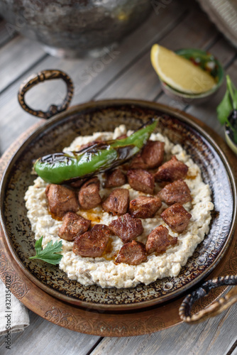 Turkish Sauteed Lamb Meat Served with Smoked Eggplant and Yogurt Puree, Garnished with Grilled Hot Pepper. Ali Nazik Kebab