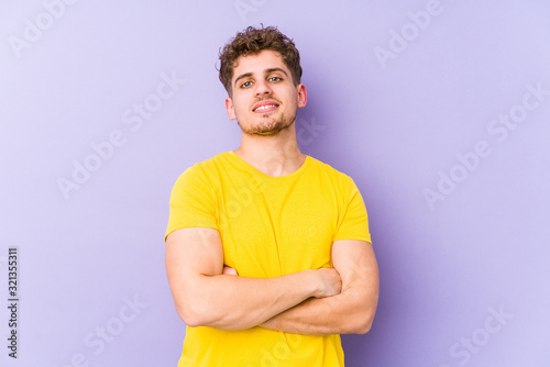 Young blond curly hair caucasian man isolated suspicious, uncertain, examining you.