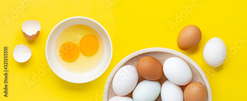 Fresh eggs on yellow background.