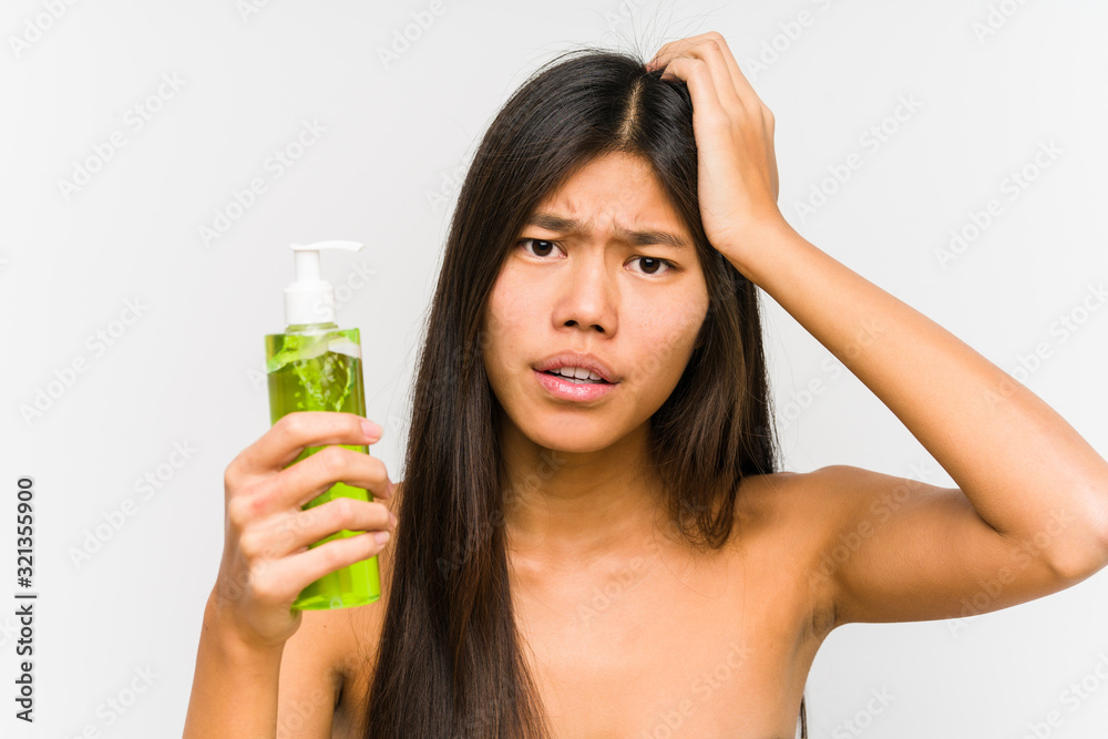 Young chinese woman holding a moisturizer with aloe vera isolated being shocked, she has remembered important meeting. Young chinese woman holding a moisturizer with aloe vera isolated being shocked, she has remembered important meeting.