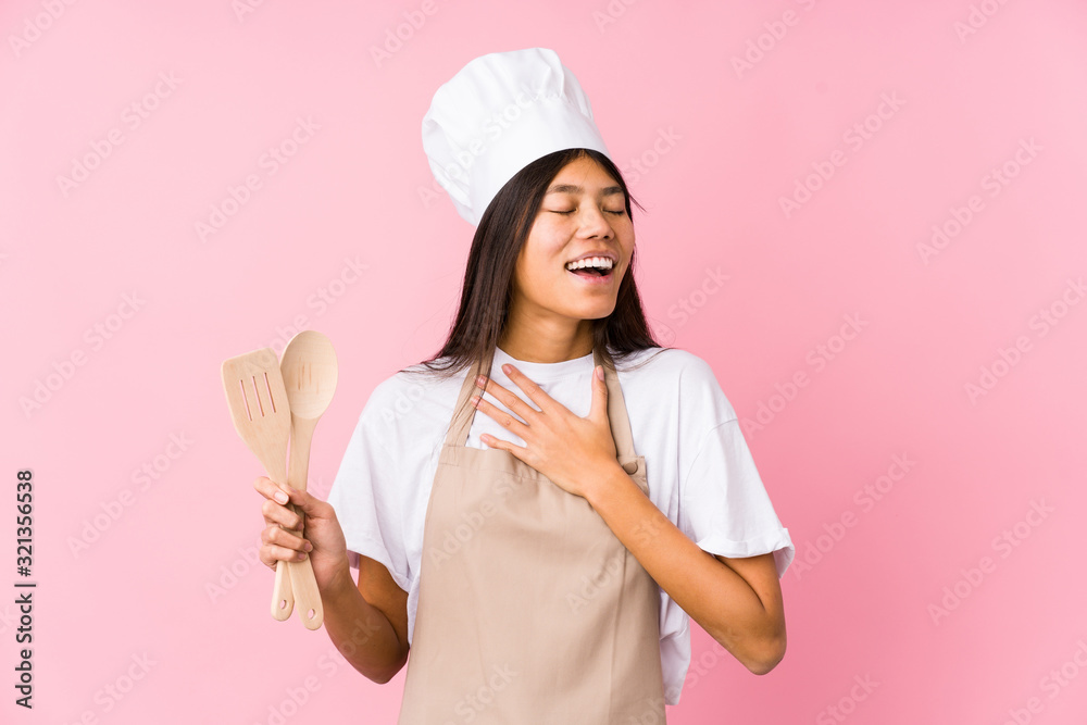 Young chinese chef woman isolated laughs out loudly keeping hand on chest. Young chinese chef woman isolated laughs out loudly keeping hand on chest.