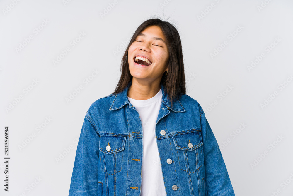 Young asian woman relaxed and happy laughing, neck stretched showing teeth. Young asian woman relaxed and happy laughing, neck stretched showing teeth.