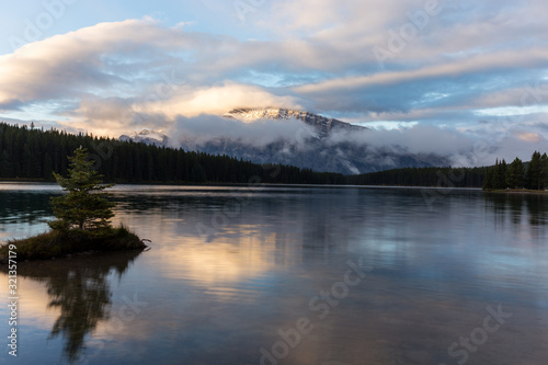 Lake in Banff National Park at sunrise with cloudy sky at sunrise