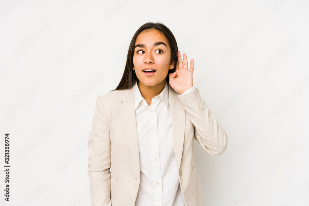 Young woman isolated on a white background trying to listening a gossip. Young woman isolated on a white background trying to listening a gossip.