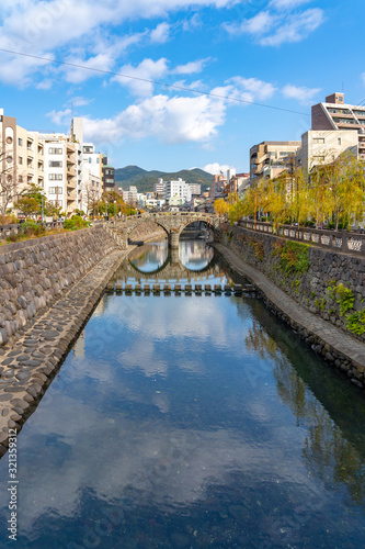 Megane Bridge (Spectacles Bridge) in sunny day with beautiful blue sky reflection on surface. one of the three most famous bridges in Japan. Nagasaki City, Nagasaki Prefecture, Japan photo