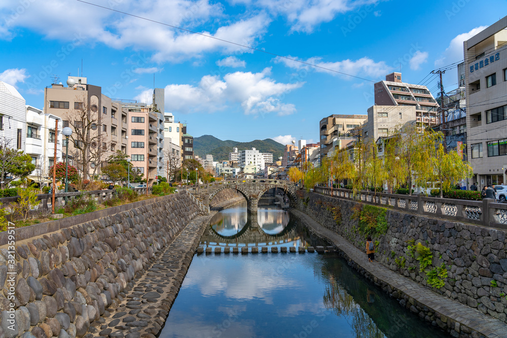 Megane Bridge (Spectacles Bridge) in sunny day with beautiful blue sky reflection on surface. one of the three most famous bridges in Japan. Nagasaki City, Nagasaki Prefecture, Japan