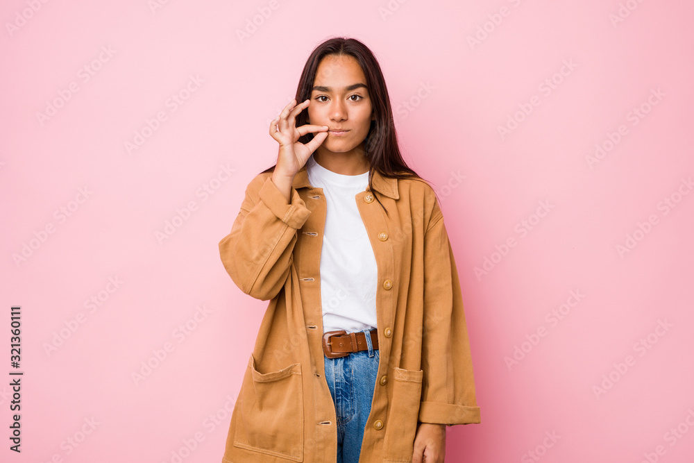 Young mixed race indian woman isolated with fingers on lips keeping a secret. Young mixed race indian woman isolated with fingers on lips keeping a secret.