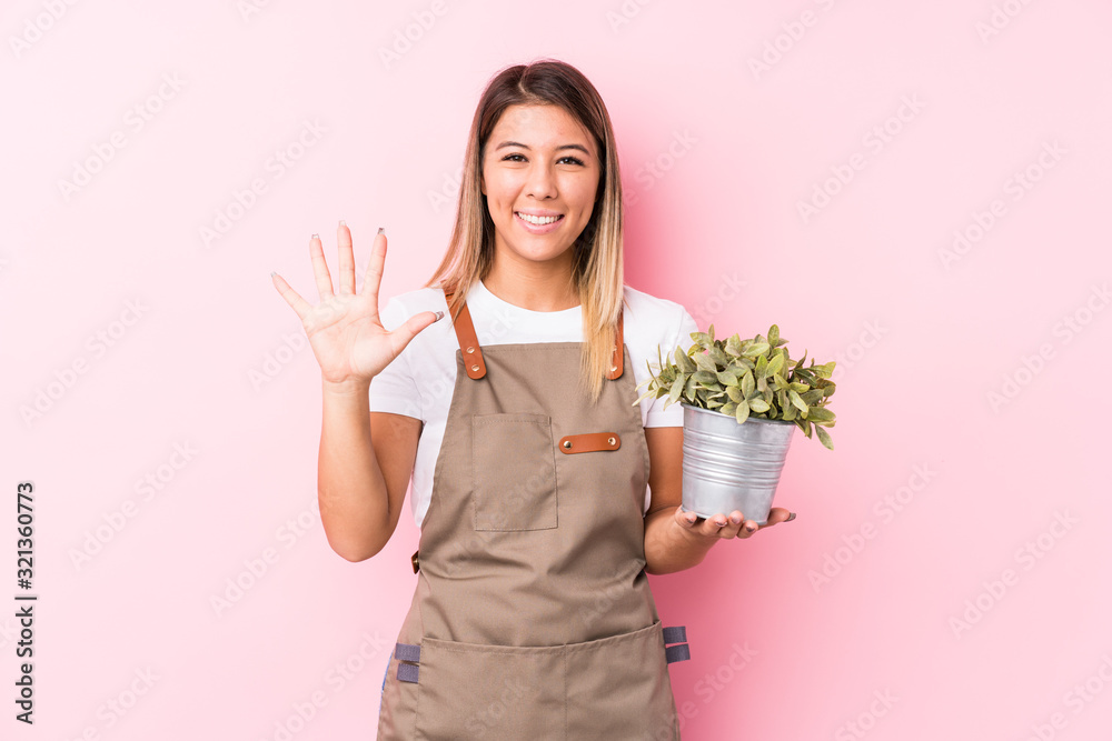Young gardener caucasian woman isolated smiling cheerful showing number five with fingers. Young gardener caucasian woman isolated smiling cheerful showing number five with fingers.