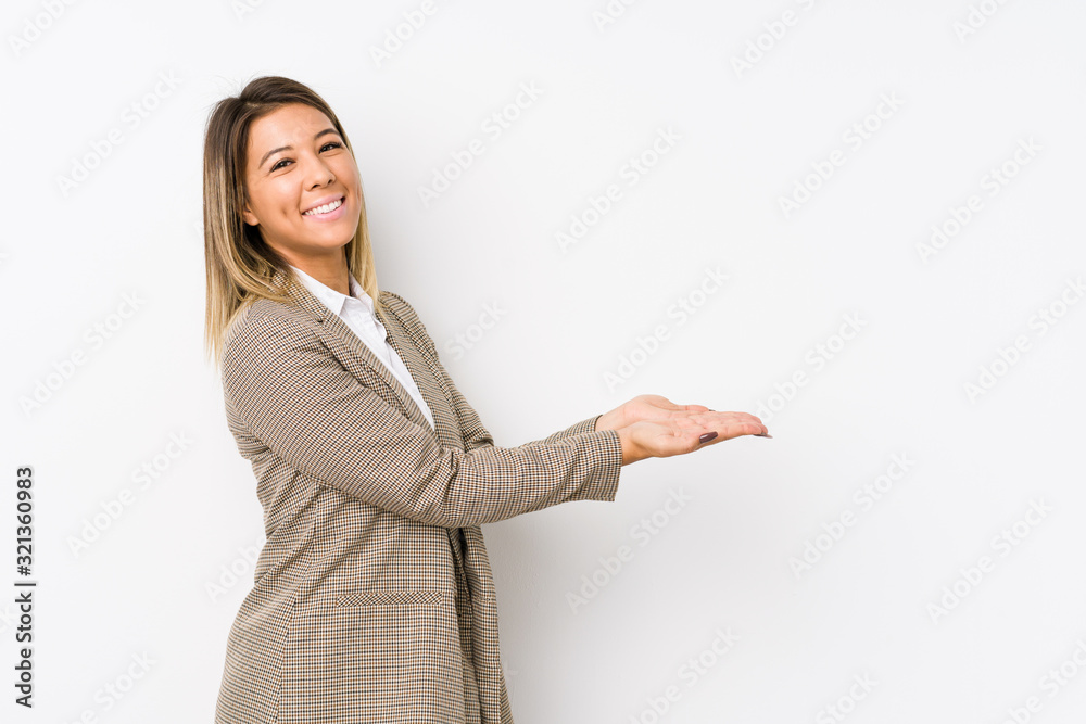 Young caucasian business woman isolated holding a copy space on a palm. Young caucasian business woman isolated holding a copy space on a palm.