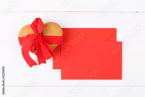 Heart shaped cookies with red ribbon and red mockup greenting card on a white backround. Simbol of cozy love and Valentines Day backrgound photo