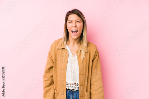 young caucasian woman posing isolated screaming very angry and aggressive. © Asier