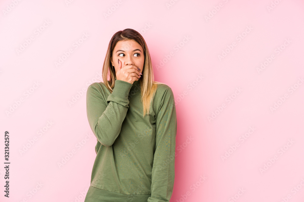 Young caucasian woman posing isolated thoughtful looking to a copy space covering mouth with hand. Young caucasian woman posing isolated thoughtful looking to a copy space covering mouth with hand.