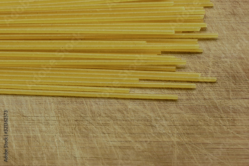 Close-up of Uncooked Spaghetti On A Scratched Wooden Cutting Board, Top View