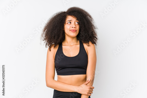 Young african american sporty woman confused, feels doubtful and unsure.