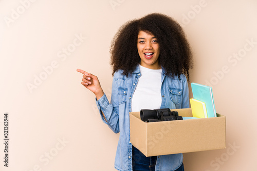 Young afro woman moving home isolated Young afro woman pointing to the side © Asier