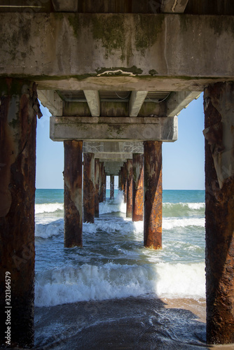 Calm ocean water view under pier © Jazmine