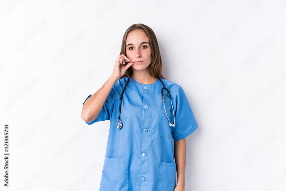 Young nurse woman isolated with fingers on lips keeping a secret. Young nurse woman isolated with fingers on lips keeping a secret.