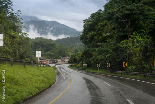 Road wet by rain among lush vegetation. Colombia