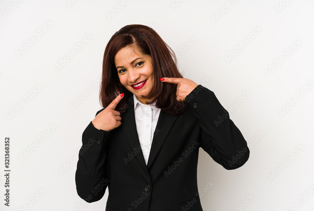 Middle age latin business woman isolated smiles, pointing fingers at mouth. Middle age latin business woman isolated smiles, pointing fingers at mouth.