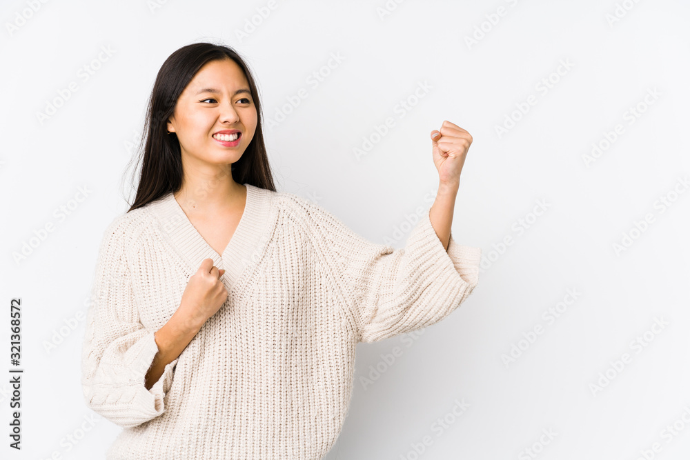 Young chinese woman isolated raising fist after a victory, winner concept. Young chinese woman isolated raising fist after a victory, winner concept.