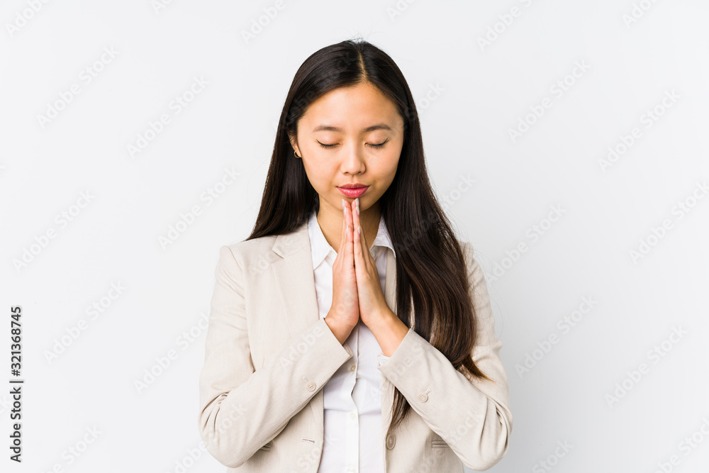 Young chinese business woman isolated holding hands in pray near mouth, feels confident. Young chinese business woman isolated holding hands in pray near mouth, feels confident.