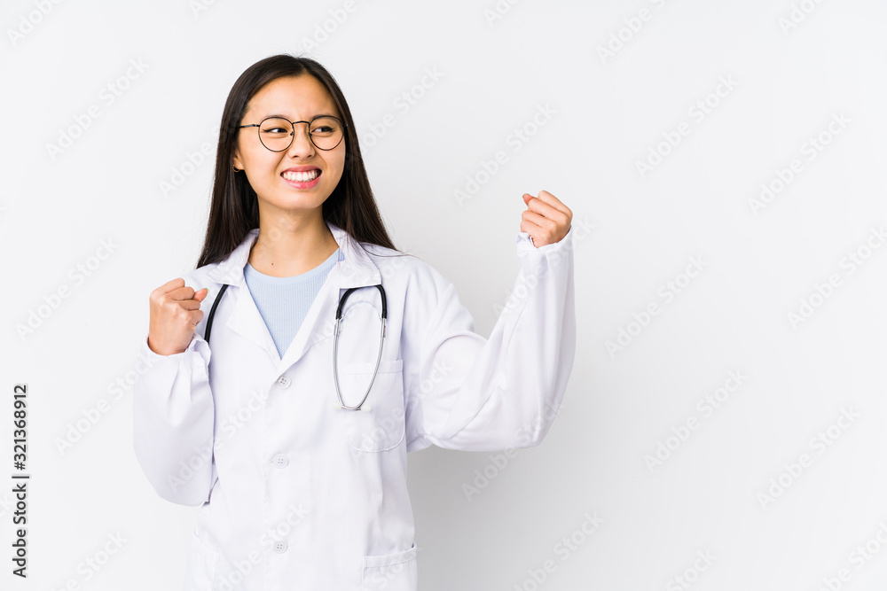 Young doctor chinese woman isolated raising fist after a victory, winner concept. Young doctor chinese woman isolated raising fist after a victory, winner concept.