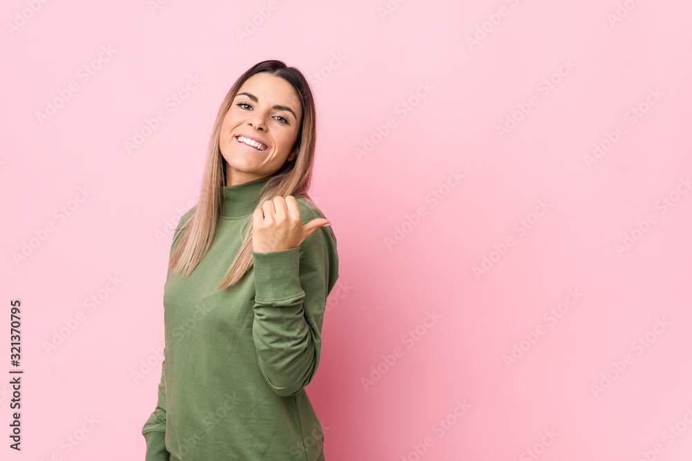 Young caucasian woman isolated points with thumb finger away, laughing and carefree. Young caucasian woman isolated points with thumb finger away, laughing and carefree.