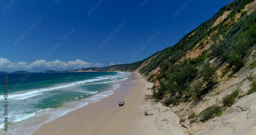 4k decending aerial view of the beach and 4x4 vehicles and coloured sand dunes near the township of Rainbow beach, the beach is accessible with a 4x4 vehicle dependent on tides,Queensland,Australia 4k decending aerial view of the beach and 4x4 vehicles and coloured sand dunes near the township of Rainbow beach, the beach is accessible with a 4x4 vehicle dependent on tides,Queensland,Australia