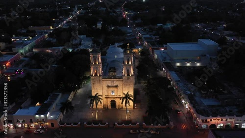 Slow nighttime aerial pull back from the Catedral de San Gervasio in Valladolid, Yucatan, Mexico. photo