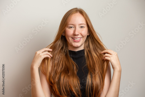 Portrait of beautiful cheerful redhead girl smiling laughing looking at camera over white background.