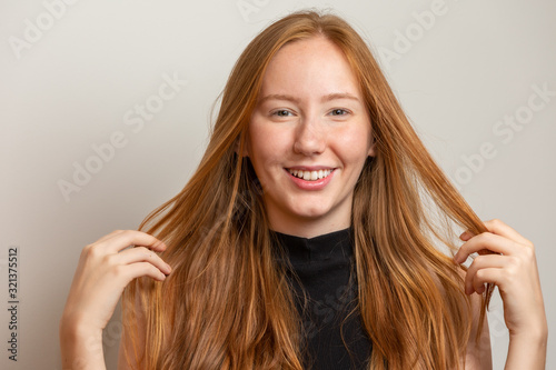 Portrait of beautiful cheerful redhead girl smiling laughing looking at camera over white background.