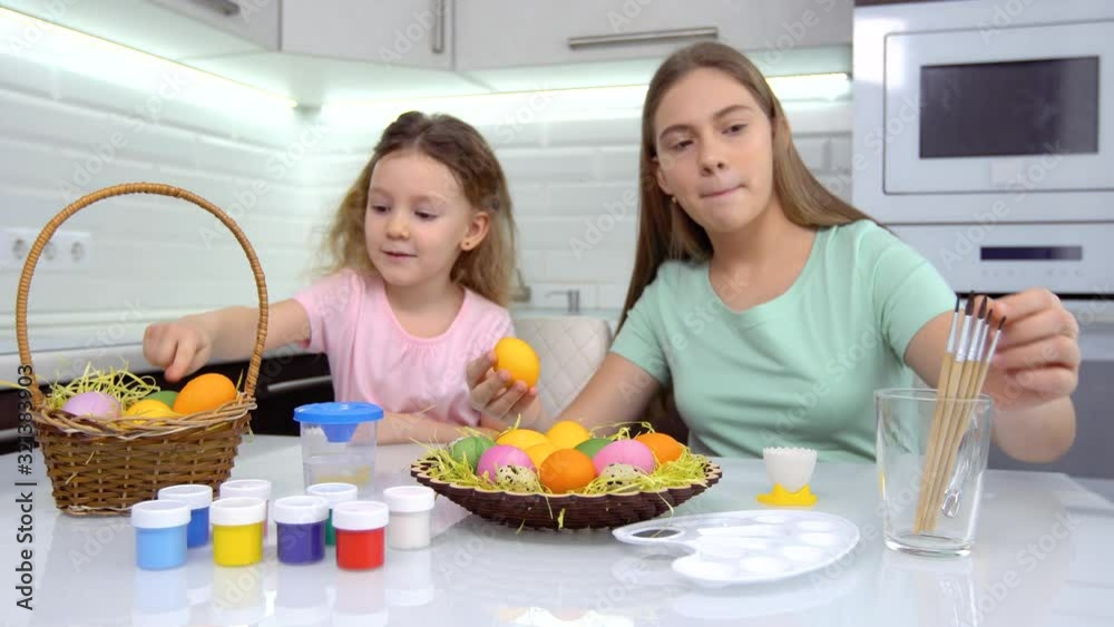 Happy easter. Two sisters painting Easter eggs. Happy family children preparing for Easter. Cute little child girl wearing bunny ears on Easter day. Happy easter. Two sisters painting Easter eggs. Happy family children preparing for Easter. Cute little child girl wearing bunny ears on Easter day.