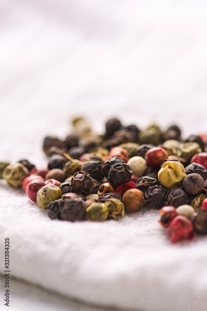Pile of peppercorns on a white cloth napkin. Pile of peppercorns on a white cloth napkin.