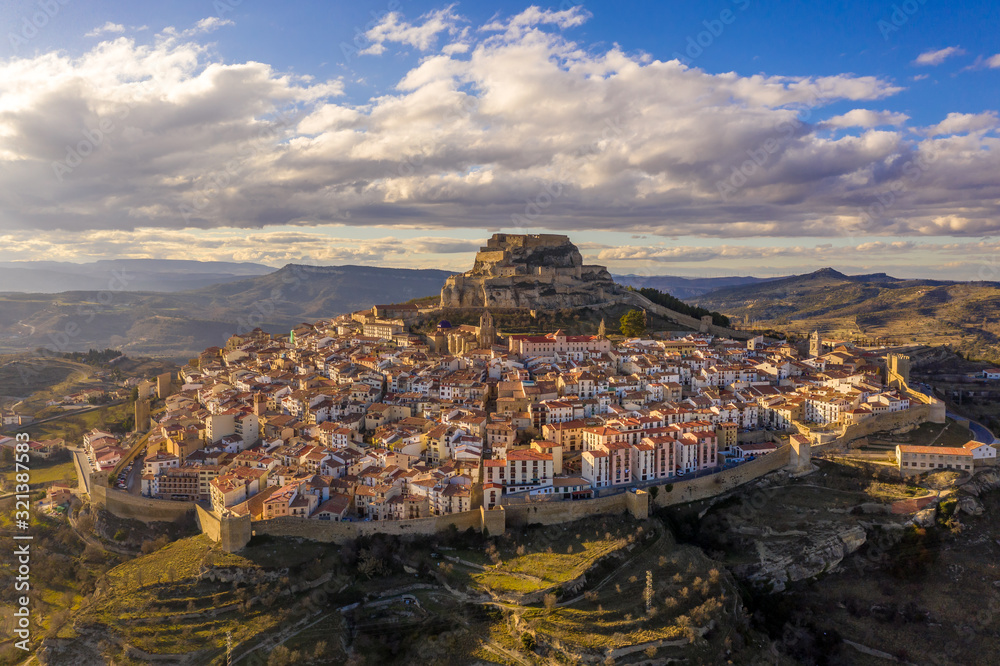Aerial winter afternoon view of walled medieval Morella with crenelated towers in Central Spain
