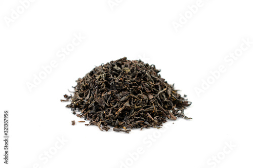 Pile of dry black tea leaves on a white background close-up.