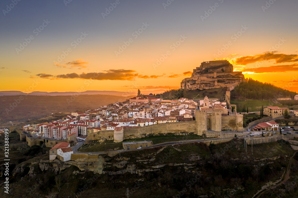 Aerial sunset view of Morella castle and town in central Spain with surrounding medieval walls, towers and winter festival