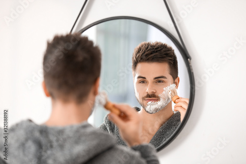 Handsome young man shaving ...