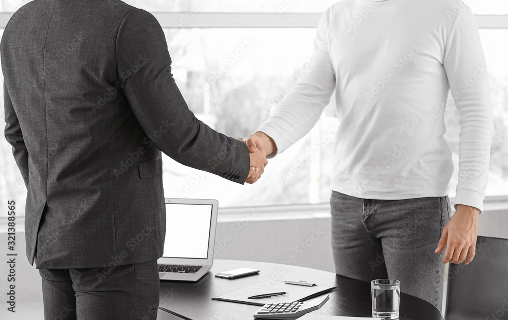 Fototapeta premium Bank manager and man shaking hands in office