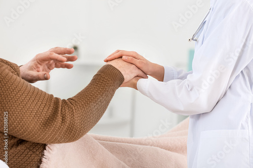 Doctor holding patient's ha...