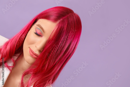 Beautiful young woman with unusual hair on color background