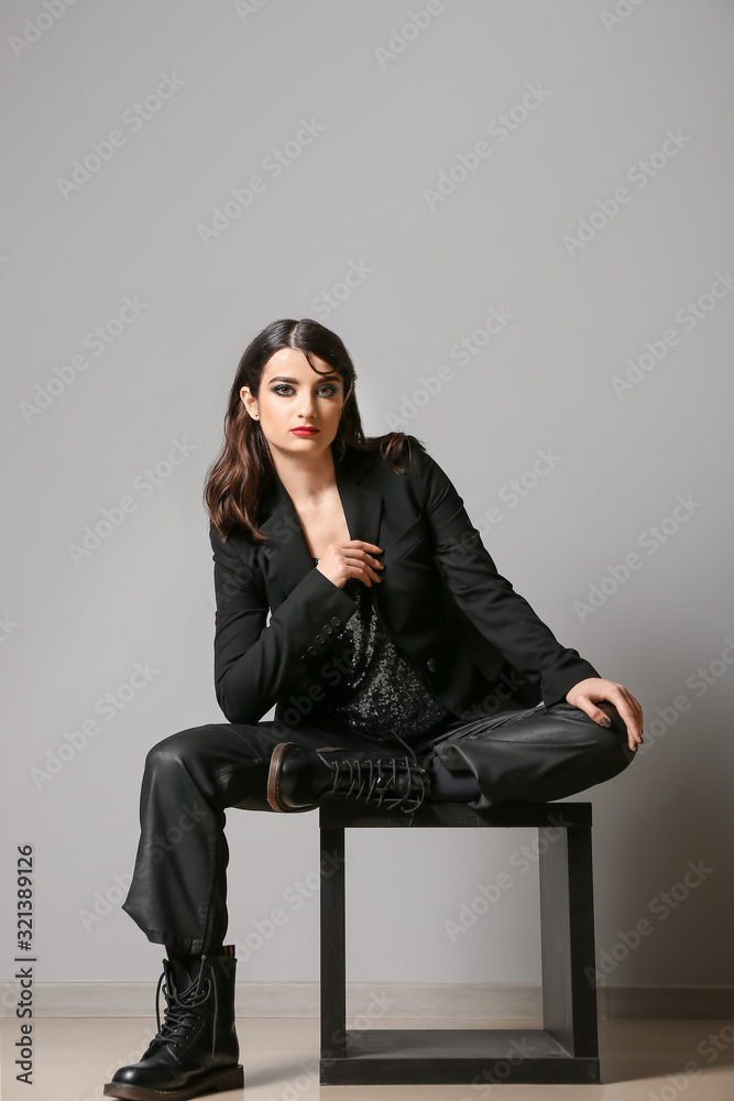 Beautiful fashionable woman near light wall Beautiful fashionable woman near light wall