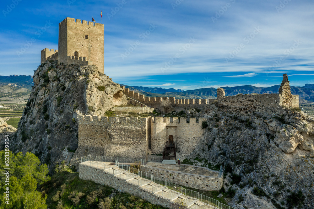 Aerial view of medieval restored Sax castle with two rectangular towers and two semi circular towers protecting the gate near Alicante Spain
