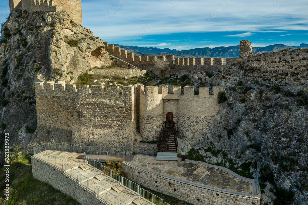 Aerial afternoon view of Sax castle gate protected by two semi circular towers guarding the entrance to the lower bailey courtyard in Spain
