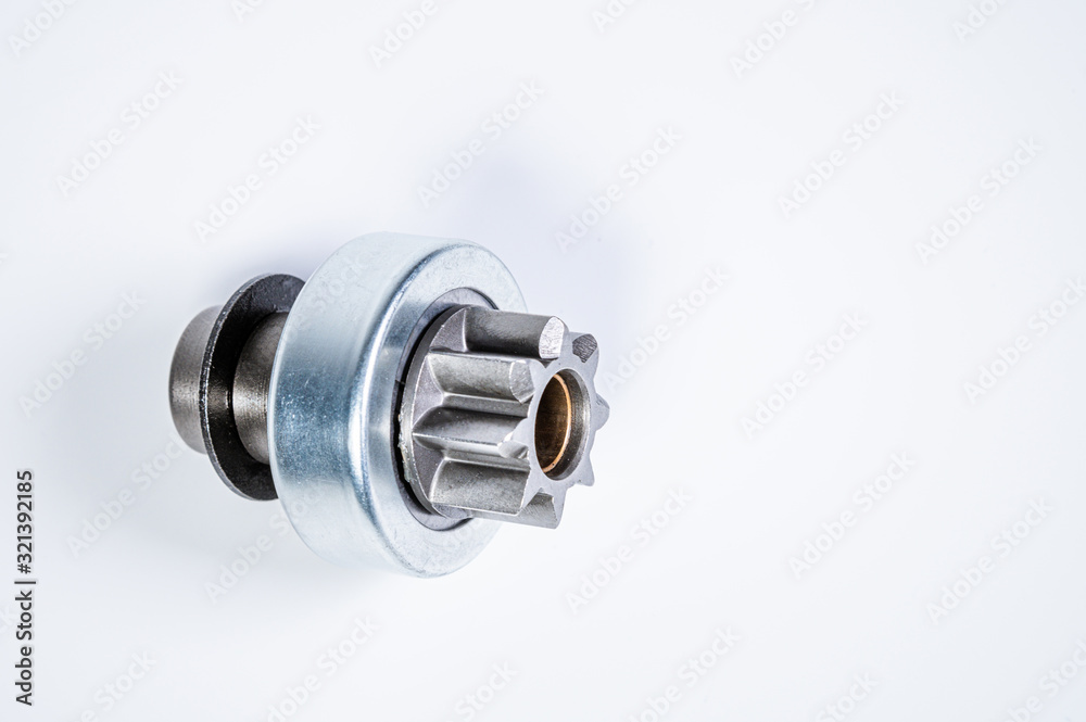 New spare parts - starter gear drive for motor starter on a gray background. Classic gear transmission via torque transmission New spare parts - starter gear drive for motor starter on a gray background. Classic gear transmission via torque transmission