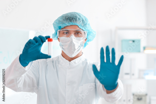 Scientist with sample in test tube in laboratory. Concept of epidemic